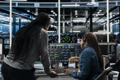 Server room manager oversees work done by engineer using artificial intelligence Stock Photos