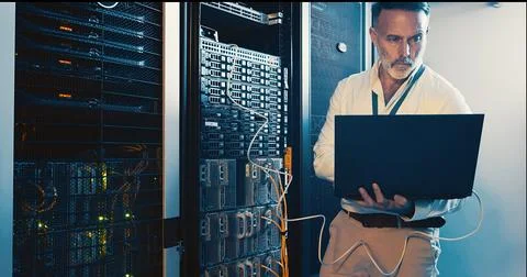 Server room, programmer and man with laptop, tech upgrade and hardware problem Foto stock