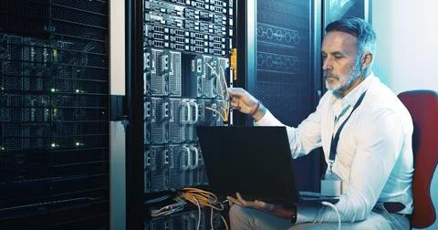 Server room, programmer and man with laptop, hardware problem solving and Stock Photos