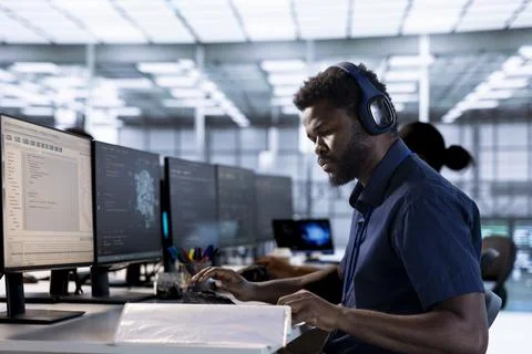 Server room programmer listening music, looking over paperwork Stock Photos