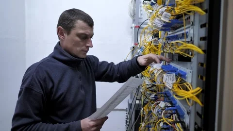 Server room. The system administrator checks the optical cables Stock Footage 248074472