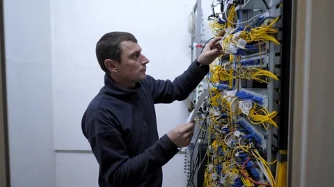 Server room. The system administrator checks the optical cables Stock Footage 248074583