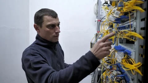 Server room. The system administrator checks the optical cables Stock Footage 248074651
