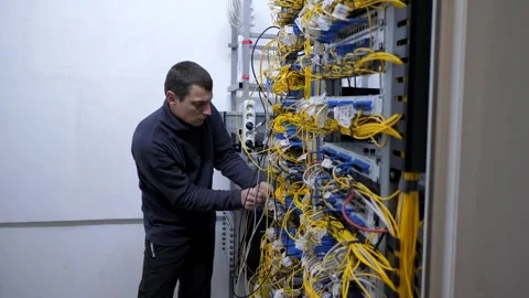 Server room. The system administrator checks the optical cables Stock Footage 248074701