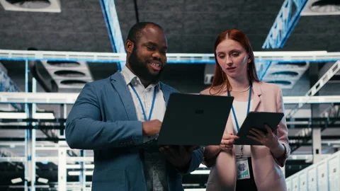 Server room teamworking colleagues using tablet and laptop Stock Footage 330031453