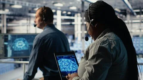 Server room tech support employee using AI on tablet to guide clients Stock Photos