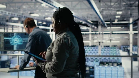 Server room tech support specialist guides clients set up data backups Stock Footage 314804529