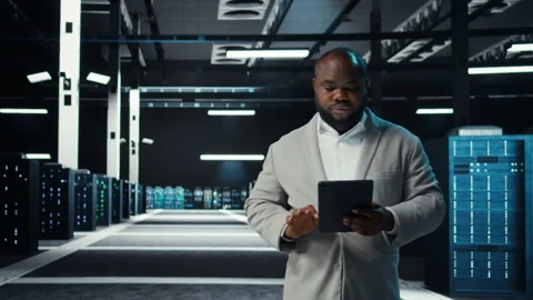Server room technician doing troubleshooting using tablet to prevent downtime Stock Footage 311897332
