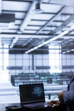 Server room worker running code on laptop to upgrade artificial intelligence Stock Photos