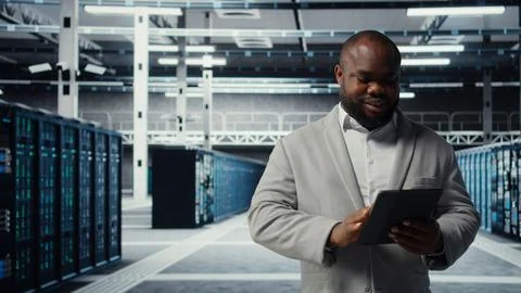 Server room worker troubleshooting server connectivity issues using tablet Stock Photos