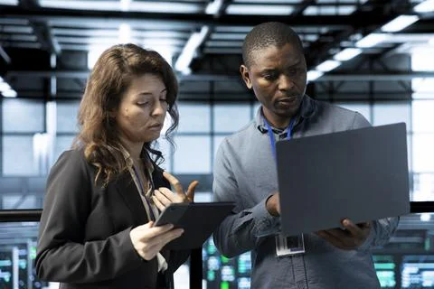 Server room workers using devices to perform vulnerability scans Stock Photos