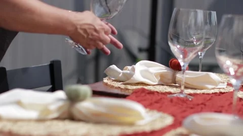 Server setting wine glasses on a table outdoors Stockbeeldmateriaal 317602342