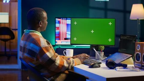 Server technician optimizing program and next to green screen Stock Photos