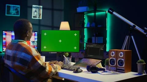 Server technician optimizing program and next to green screen Foto stock