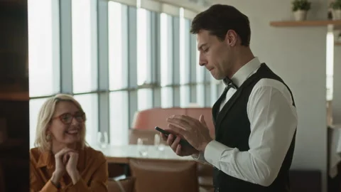 Server Using Gadget while Taking Order in Restaurant Stock Footage 309014316