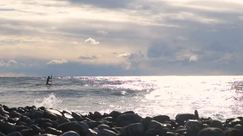A server waiting for a big wave with an oar is rowing on the water Stock Footage 169810289