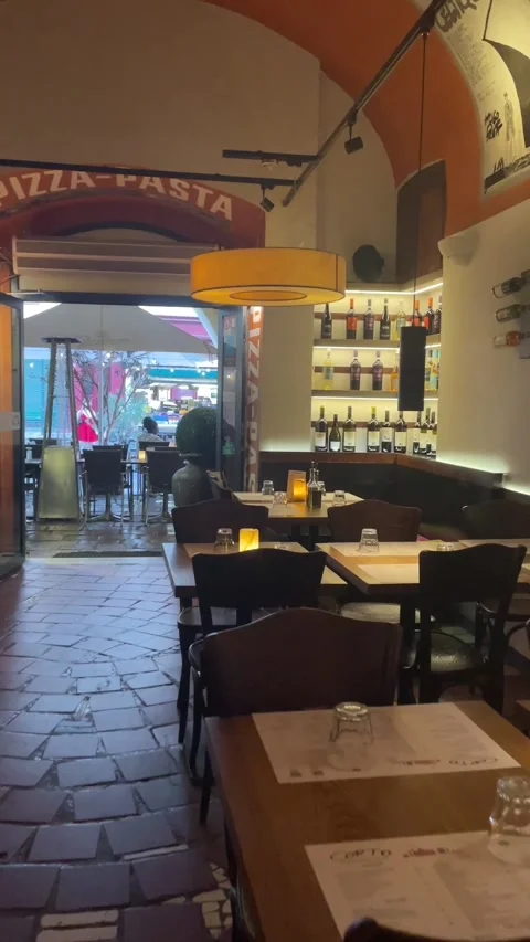 Server walks through doorway from cozy italian restaurant interior toward 库存影片 344585163