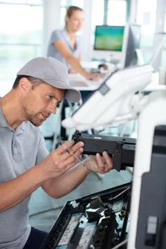 Service agent is maintaining an office printer Stock Photos