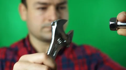 Service and engineering concept. Man with serious face in uniform holds wrench Stock Footage 87137441