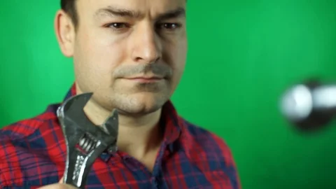 Service and engineering concept. Man with serious face in uniform holds wrench Stock Footage 87174810