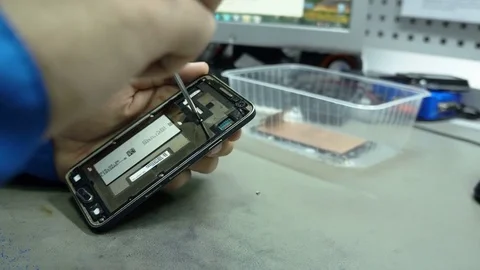Service center. Electronics repair shops. The repair of the smartphone. Man Stock Footage 82760340