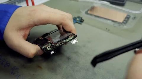 Service center. Electronics repair shops.The repair of the smartphone. Man Stock Footage 82764879