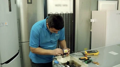 Service center. Electronics repair shops. A man repairs the fridge. Aluminum Stock Footage 82767747