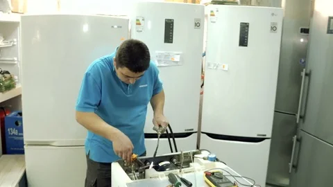 Service center. Electronics repair shops. A man repairs the fridge. Aluminum Stock Footage 82798657