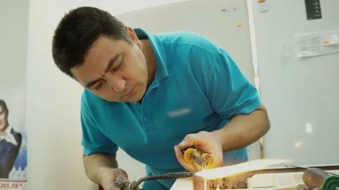 Service center. Electronics repair shops. A man repairs the fridge. Aluminum Stock Footage 82802627