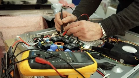 Service center. Electronics repair shops. A man repairs the hob. Multimeter. Stock Footage 82806064