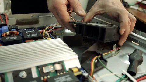 Service center. Electronics repair shops. A man repairs the hob. Multimeter. Stock Footage 82806732