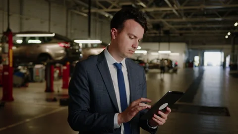 Service center. A man with a tablet makes an application for car repair Stock Footage 256074420