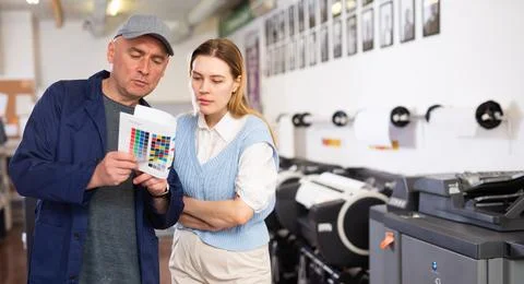 Service engineer and office worker checking color chart test page together Stock Photos