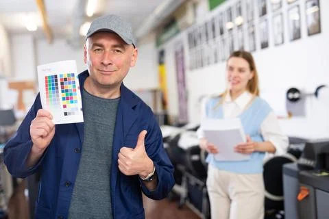 Service engineer demonstrating test page with color palette in his hand Stock Photos