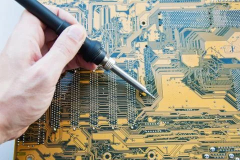Service engineer electronics using soldering iron performs repair of printed  Stock Photos