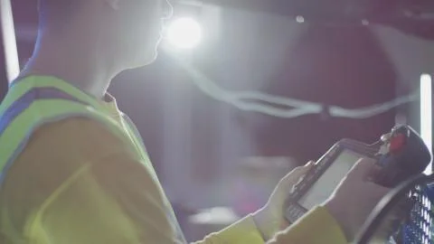 Service engineer programs industrial robot arm using portable teach pendant Stock Illustration