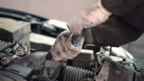 In service hand of master use tool to tighten bolts under hood of sedan closeup Stock Footage 155965720