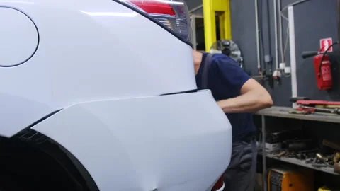 Service mechanic inspects large trunk of modern car Stock Footage 317633647