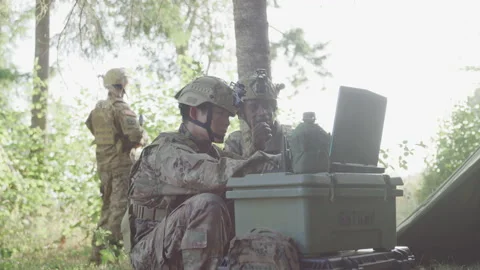 Service Members on Deployment Outside Looking at a Computer Stock Footage 208790893