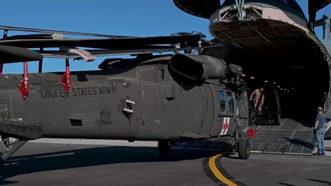 Service members loading U.S. Army UH-60 Black Hawk onto C-5 Super Galaxy Video stock 239057276
