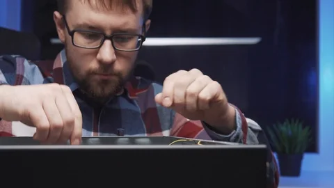 The service repairman disassembles the PC system unit, dismounts the video card 库存影片 115084745