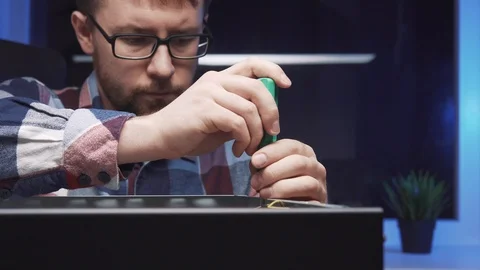 The service repairman disassembles the PC system unit, dismounts the video card Stock Footage 115084779