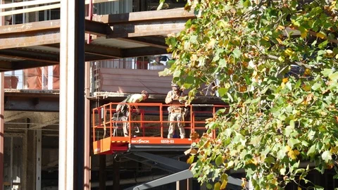 Service workers doing work on the side of the building on a skyjack Stock-Footage 83022567