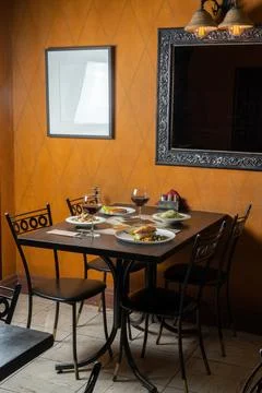 A serviced table in a small restaurant. There are a couple of glasses of wine. Stock Photos