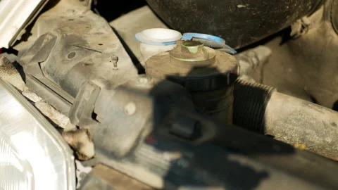 Serviceman is adding antifreeze and closes the cap of the tank Stock Footage 165866097