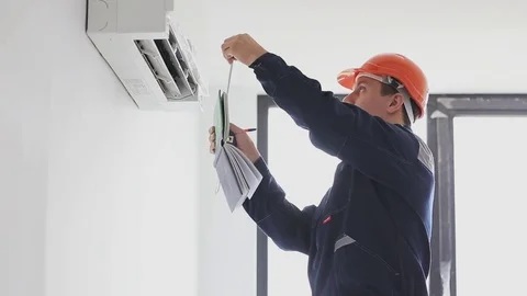 Serviceman inspects and measures a air conditioning Stock Footage 76985972