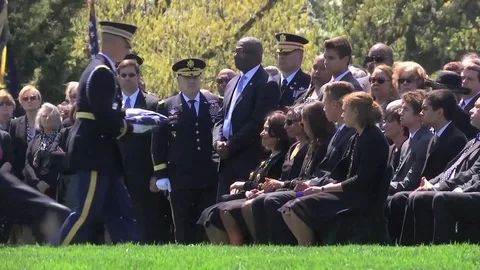 Serviceman presents mourner with U.S. flag during funeral ceremony Stock Footage 90120280