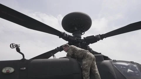 Serviceman service Apache military chopper checking errors with laptop. Prefligh Stock Footage 246650287
