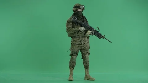Serviceman standing with weapon and looking at side at green screen 動画素材 70430991