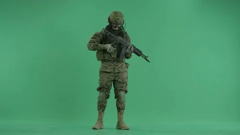 Serviceman standing with weapon and reloading it at green screen 動画素材 70441905